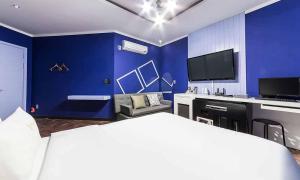 a blue room with a bed and a tv at Paju Picasso in Paju