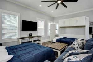 a bedroom with two beds and a flat screen tv at Renovated Beach Bungalow! in Galveston