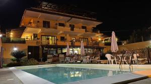 um hotel com piscina em frente a um edifício em Mare e Monti em Trivio