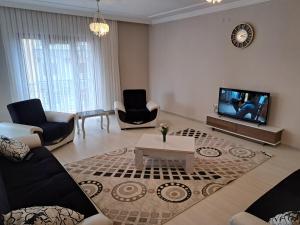 a living room with a couch and a tv at AKUA 23 in Trabzon