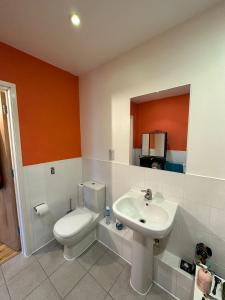 a bathroom with a toilet and a sink at Repton house in Woodford