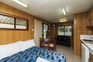 a small bedroom with a bed and a kitchen at Reflections Scotts Head - Holiday Park in Scotts Head