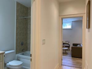 a bathroom with a toilet and a bath tub at One Deluxe Bedroom Suite in Midtown in Toronto