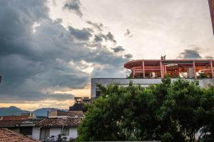 a building with a balcony on top of it under a cloudy sky at Vita Hotel Boutique in Medellín