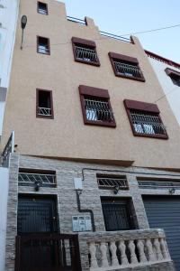 a tall building with several windows and a balcony at Dream House Sidi Ifni in Sidi Ifni
