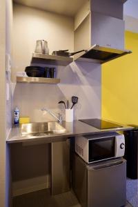 a small kitchen with a sink and a microwave at Apartment Hotel 11 Namba Minami Shin-Imamiya in Osaka