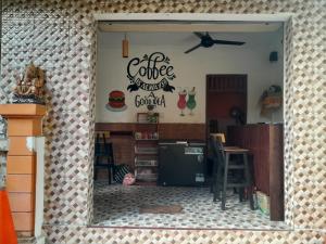 a kitchen with a coffee shop with a sign on the wall at Harmony Guest House in Padangbai
