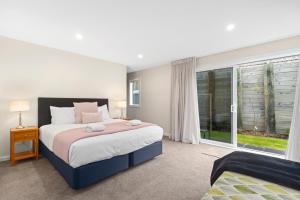 Un dormitorio con una cama grande y una ventana en Sanctuary on the Grove, en Taupo