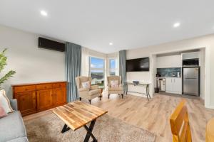 a living room with a table and a kitchen at Sanctuary on the Grove in Taupo