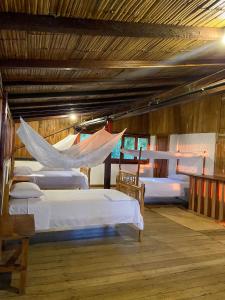 a room with four beds with hammocks in it at Mompiche Island Hostel in Mompiche