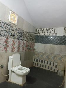 a bathroom with a toilet and a clock on the wall at Night Stay Camp in Jaisalmer