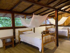 1 dormitorio con 2 camas en una habitación con ventanas en Mompiche Island Hostel, en Mompiche