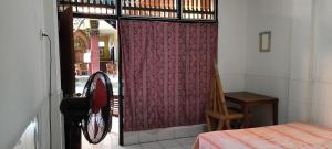 a room with a window with a red curtain at Dharma homestay in Padangbai