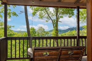 a view from the porch of a cabin with a bench at King Beds, VIEWS, Fire Pit, Spa, No Fees, New, Private, Games in Sevierville