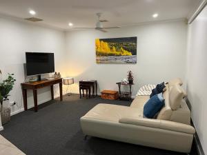 uma sala de estar com um sofá e uma televisão de ecrã plano em Watergardens Lodge em Taylors Lakes