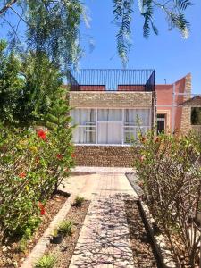 una casa de ladrillo con una pasarela delante de ella en Essaouira, en Tagaouaout