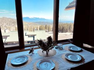 uma mesa com pratos azuis numa mesa com uma janela em Ski-in, Ski-out Whitefish Mountain Condo with Views and Pet Friendly em Whitefish