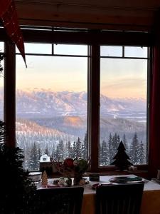 uma mesa com vista para a montanha a partir de uma janela em Ski-in, Ski-out Whitefish Mountain Condo with Views and Pet Friendly em Whitefish
