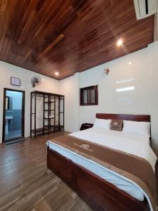 a bedroom with a large bed and a wooden ceiling at Ngọc Anh homestay in Thôn Kim Long (1)