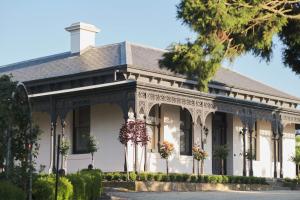 una vieja casa blanca con flores delante en Marnong Estate en Craigieburn