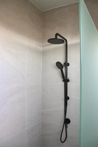 a shower with a black shower head in a bathroom at Marnong Estate in Mickleham