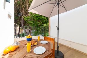 - une table en bois avec un parasol et des fruits dans l'établissement Las Terrazas de Casa Gómez, à Almería