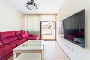 a living room with a red couch and a tv at Las Terrazas de Casa Gómez in Almería