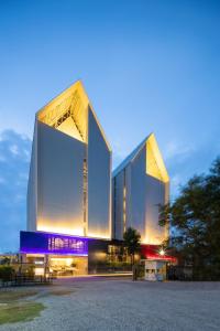 a large building with two tall towers at night at Blue Hippo Hotel in Ban Khlong Samrong
