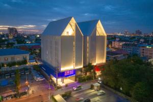 un edificio iluminado en una ciudad por la noche en Blue Hippo Hotel en Ban Khlong Samrong