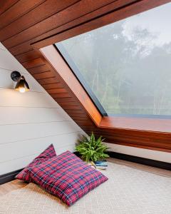 Zimmer mit einem Fenster und einem Kissen auf dem Boden in der Unterkunft Refúgio Galli in Encantado