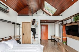a woman is on a ladder in a bedroom at Refúgio Galli in Encantado