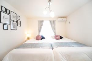 HakuroNagashima Riverside Resort 2的一间卧室配有带白色床单和粉红色枕头的床。