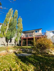 a house with a balcony on top of a yard at Private, Spacious, & Bright Home in Calgary
