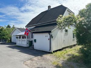 un edificio blanco con una bandera americana en él en Nedre Kjellerstuvei, Oslo House Second floor, en Lillestrøm