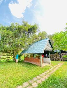 einen Pavillon mit einem grünen Dach auf einem Feld in der Unterkunft Meegahapokuna Resort in Anuradhapura