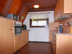 une grande cuisine avec des placards en bois et une fenêtre dans l'établissement Wunderschönes Ferienparadies in Krusendorf nahe des Ostseestrandes, à Krusendorf