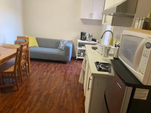 uma cozinha e sala de estar com um sofá e uma mesa em Private Basement Room 0363 em Toronto