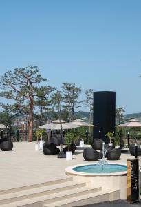 a fountain in a courtyard with chairs and umbrellas at Gunsan Stay Tourist Hotel in Gunsan