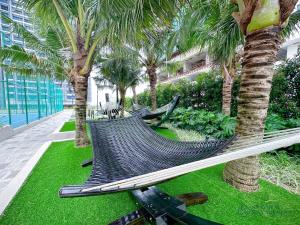 a hammock in a resort with palm trees at Bali Residences Sea View Suites Melaka in Melaka