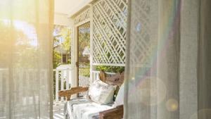 a porch with a chair and a window at Magnolia Cottage in Woorim