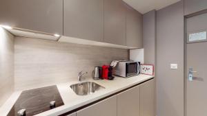 a kitchen with a sink and a microwave at Abitaziun Europa 302 - Champfèr in Champfer