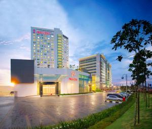 un gran edificio con coches estacionados en un estacionamiento en Premiere Hotel en Klang