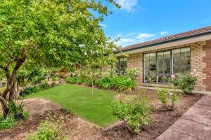 einen Garten vor einem Backsteinhaus in der Unterkunft Hahndorf Creek Retreat - Unit 2 in Hahndorf