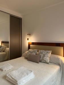 a bedroom with a large white bed with towels on it at Hermoso Depto in Corrientes
