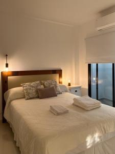 1 dormitorio con 1 cama grande y 2 toallas. en Hermoso Depto en Corrientes