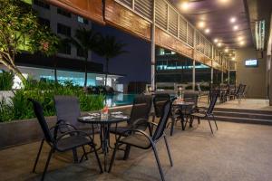 un ristorante con tavoli e sedie e una piscina di Premiere Hotel a Klang