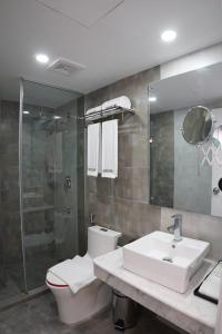 een badkamer met een toilet, een wastafel en een douche bij HOTEL STUDiO23 in Dhaka