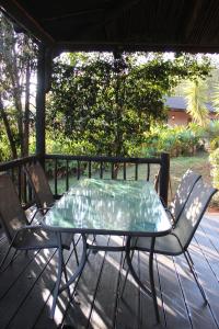 a glass table and chairs on a deck at Patogeng Self Catering - Da Gama Dam view in White River