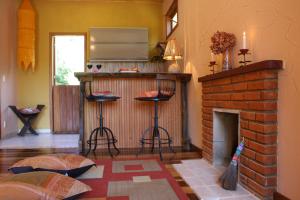 sala de estar con chimenea y cocina con taburetes en Chalé Samasati, en Visconde De Maua