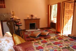een woonkamer met een open haard en een bed bij Chalé Samasati in Visconde De Maua